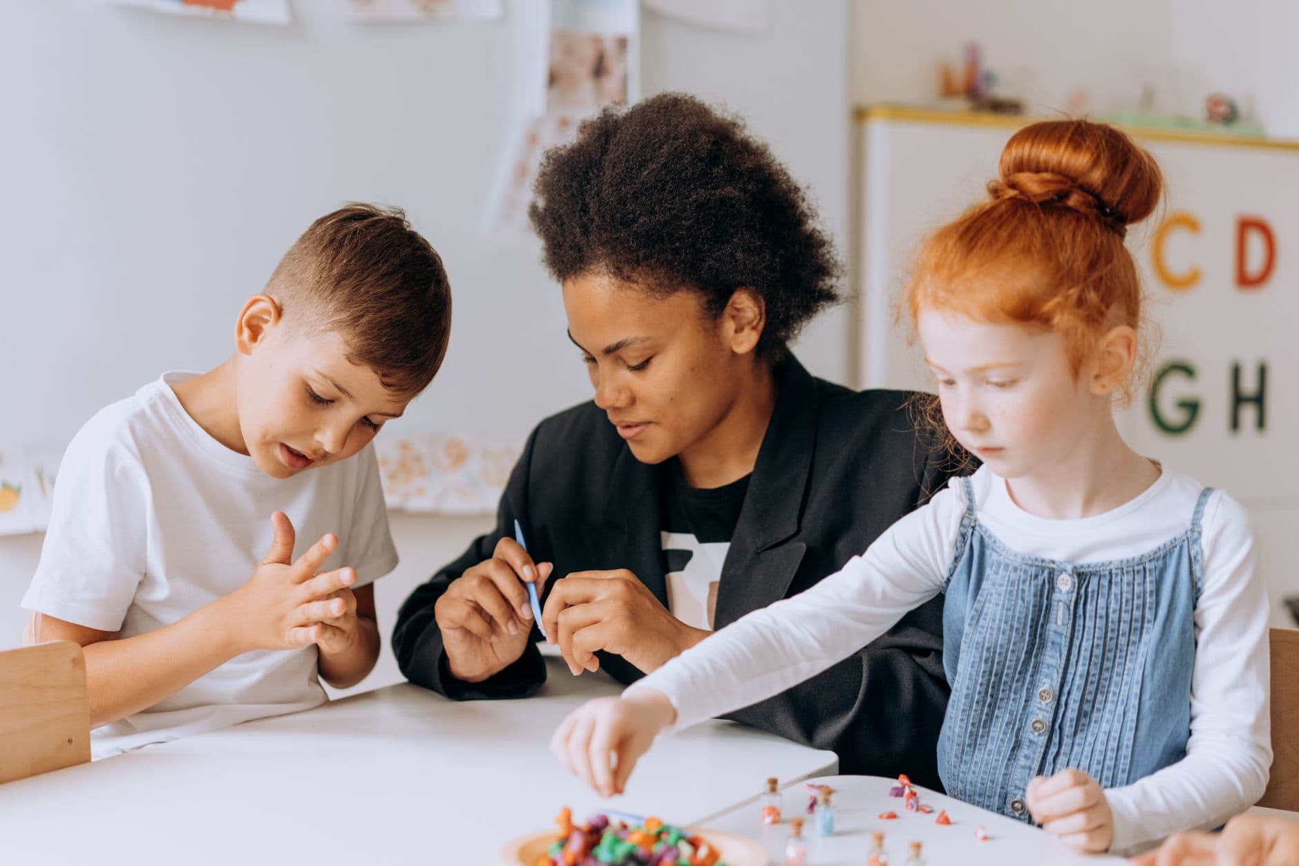 Teacher engaging with children in a classroom setting, fostering learning and creativity.