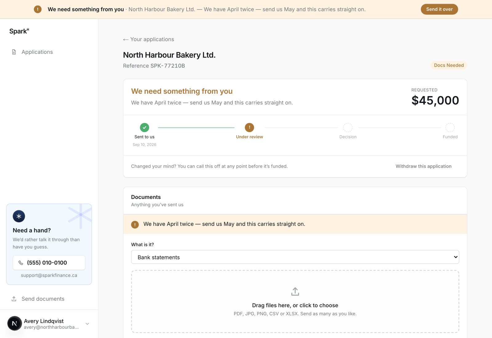 An application showing an amber banner reading we need something from you, with the specific request underneath, a tracker, and an upload panel.